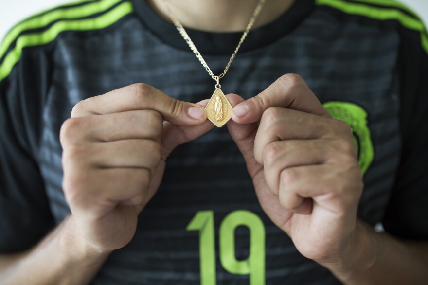 Ricardo Osuna, who graduated from Galax High School this spring, holds a Virgin Mary necklace that he wears. Osuna helped to lead the school's soccer team to the state championship title the past two years.