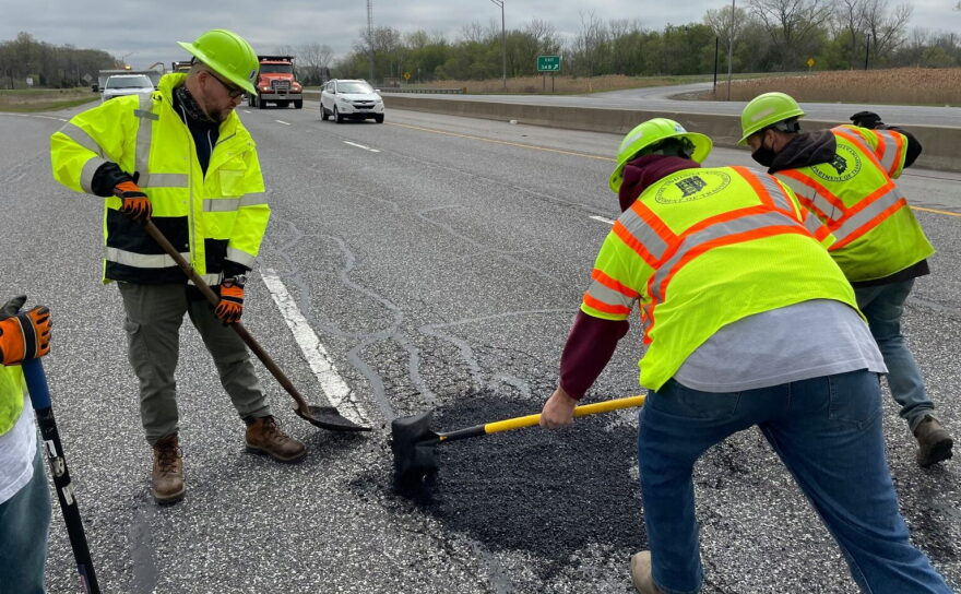 Indiana Department of Transportation workers patch a road.