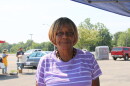 Joe Love has short blond hair and wears a purple shirt with white stripes. 