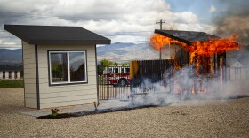 During a recent demonstration burn at the National Interagency Fire Center, one poorly prepared shed-like structure burns to the ground while the other escapes undamaged. 