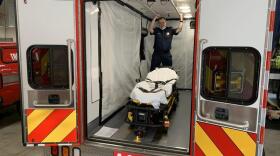 South King Fire and Rescue Lt. Greg Willett stands in an aid car optimized to transport COVID-positive patients.