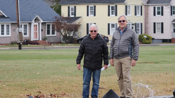Two individuals stand near a dock
