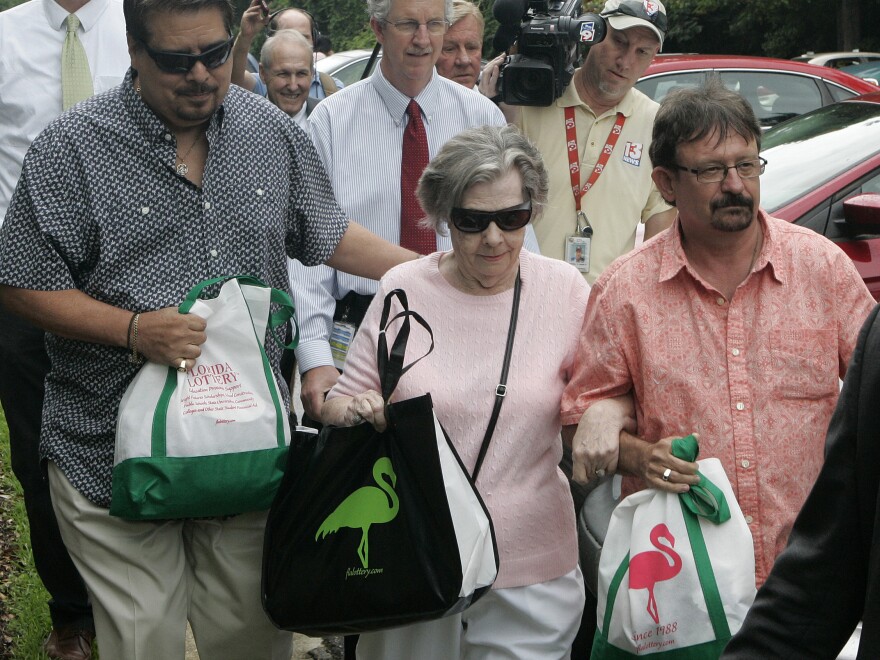 Powerball winner Gloria C. Mackenzie, 84, leaves the lottery office escorted by her son Scott (right) after claiming a single lump-sum payment of just over $370 million before taxes on Wednesday in Tallahassee, Fla. Officials say she is the largest sole lottery winner in U.S. history.