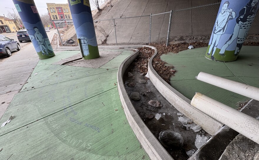 The water captured in the barrel makes its way through a rock-lined swale.