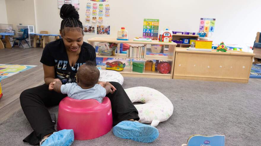 Dantasia Dale, an employee at East St. Louis’ UNI-Pres Kindercottage child care facility, plays with a restless child during nap time at the center.