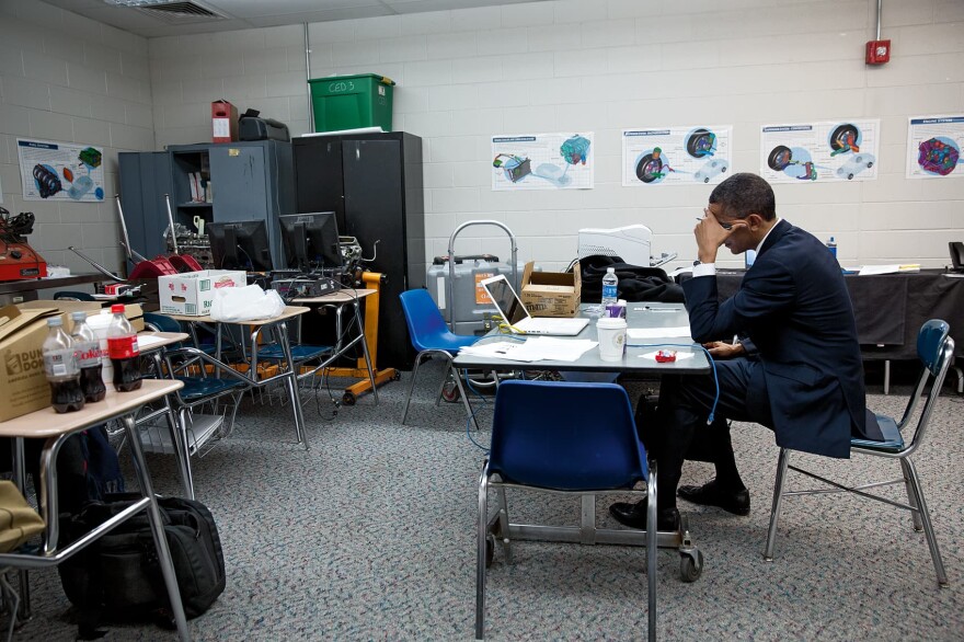 President Obama in a room of Newtown High School in Newtown, Conn., Sunday, Dec. 16, 2012. Obama works on his remarks and also signs a whiteboard near a message left for him. Obama visited Newtown to greet families of victims, first responders and others impacted by the shootings at Sandy Hook Elementary and attend a vigil. (Courtesy of Little, Brown and Company/Pete Souza)