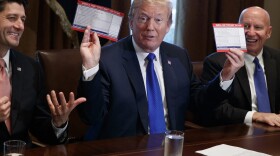 President Trump holds an example of what a new tax form may look like during a meeting on tax policy with Republican lawmakers including House Speaker Paul Ryan of Wis., and Chairman of the House Ways and Means Committee Rep. Kevin Brady, R-Texas, right, in the Cabinet Room of the White House, Thursday, Nov. 2, 2017, in Washington. (Evan Vucci/AP)