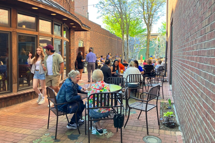 People gather in Soumas Court next to Hotel Pattee in Perry, Iowa to listen to live music in May, 2025. Photo by Rachel Cramer/Iowa Public Radio