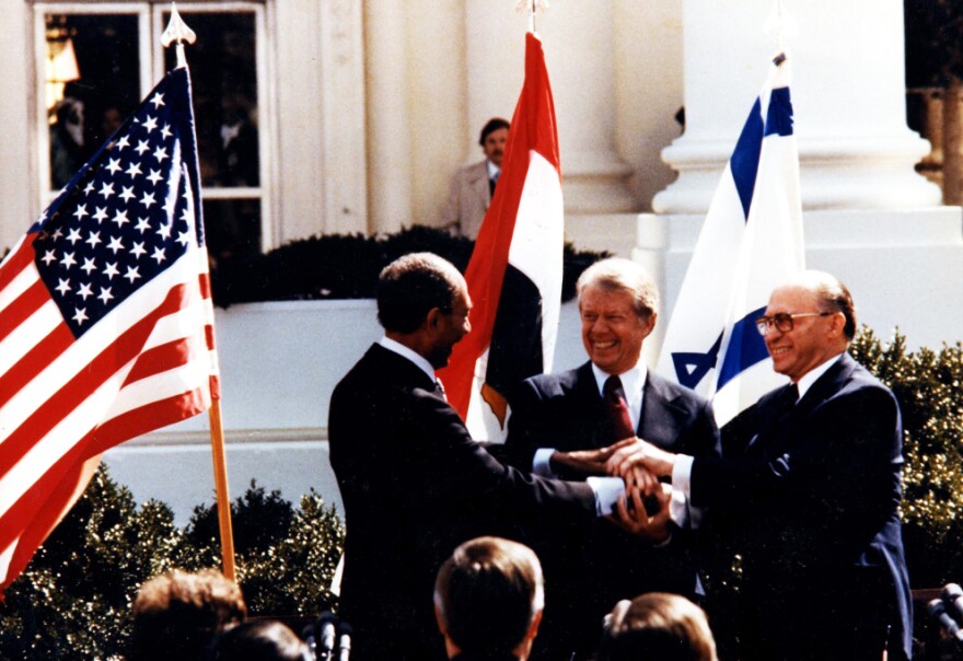 Egyptian President Anwar Sadat (left), U.S. President Jimmy Carter and Israeli Prime Minister Menachem Begin shake hands during the White House signing of the Middle East peace accord in March 1979.