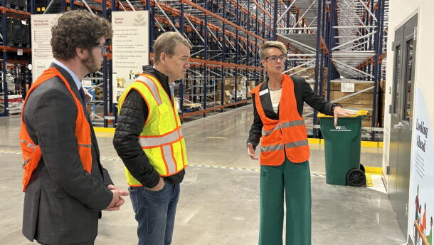 Erin Pulling, right, CEO of Food Bank of the Rockies, talks to U.S. Sen. Michael Bennet, middle, and Ron Meehan, government relations manager for Feeding Colorado in a large warehouse.