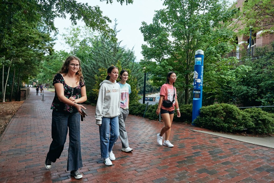 Students walk an uncharacteristically empty path at UNC following a shooting of a faculty member.