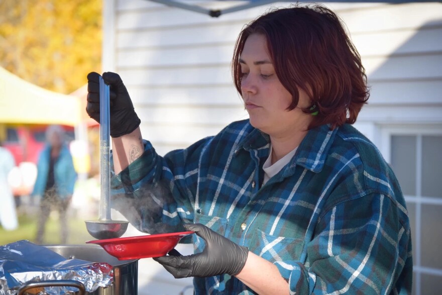 Bread Line administrator Emma DeRuyter ladles out free soup at the Southside Farmers Market in Fairbanks on Sept. 30, 2025, as part of the organization’s weekly community meal program. Many of the ingredients for the meals are donated by local farmers.