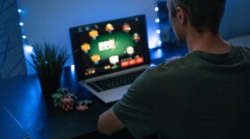 A man plays poker on a laptop.