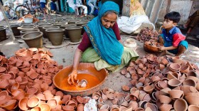 Ratnaram Diwala, 70, colors traditional earthern oil lamps at Kumbharwada. She's part of the potters colony — some 500 families — living inside the Dhavari slum area in central Mumbai.