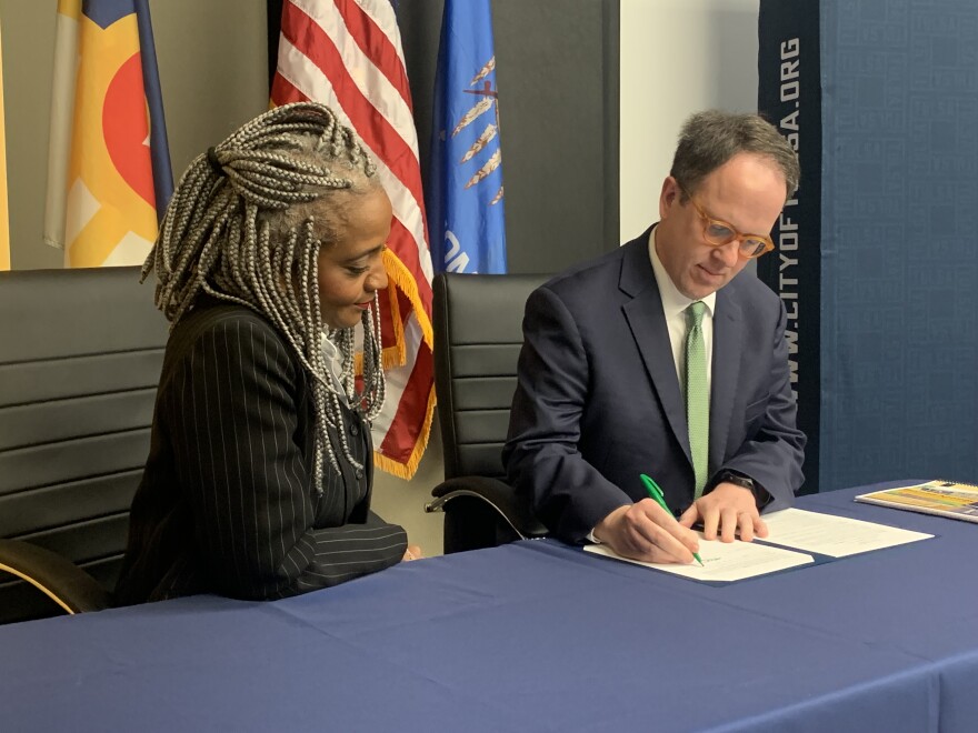 Tulsa City Councilor Vanessa Hall-Harper, left, looks on as Mayor G.T. Bynum signs an executive order creating the Beyond Apology Commission to recommend reparations for descendants of victims of the 1921 Tulsa Race Massacre on Thursday, Aug. 1, 2024, at Tulsa City Hall.