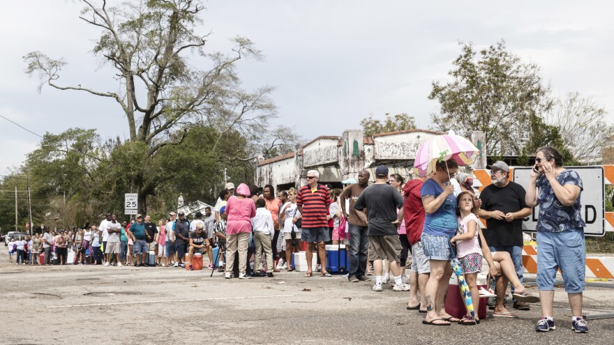 People wait in line for ice in Wilmington, N.C., on Monday.