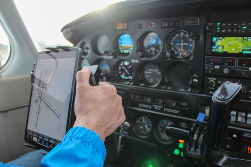 A hand at the controls of small plane.