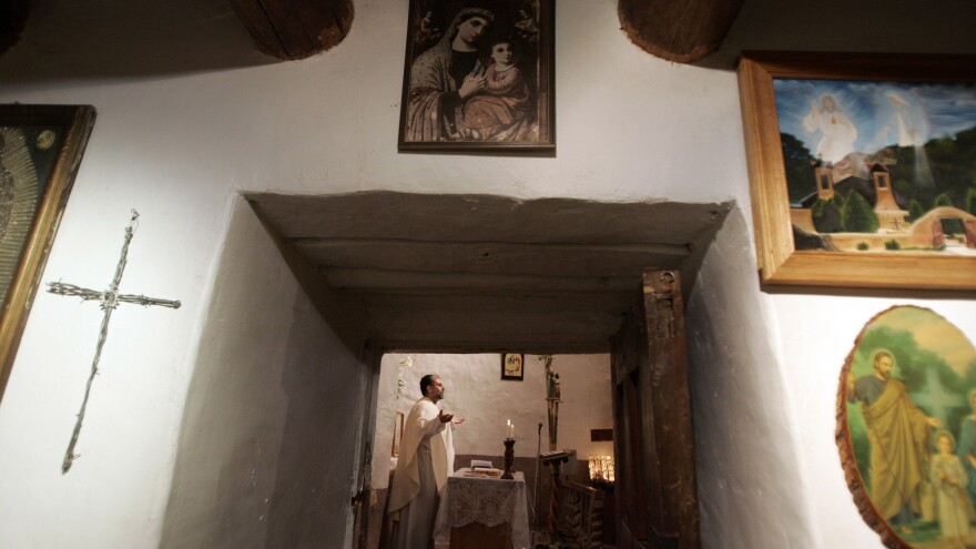 The Rev. Julio Gonzalez leads Easter Mass at El Santuario de Chimayo in 2007. Thousands of visitors make a pilgrimage to visit the small chapel annually every Easter weekend. Many people believe that the dirt inside the chapel has healing powers.