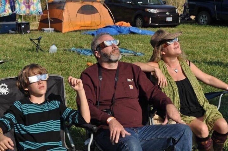 A family wears solar eclipse glasses to watch an eclipse.