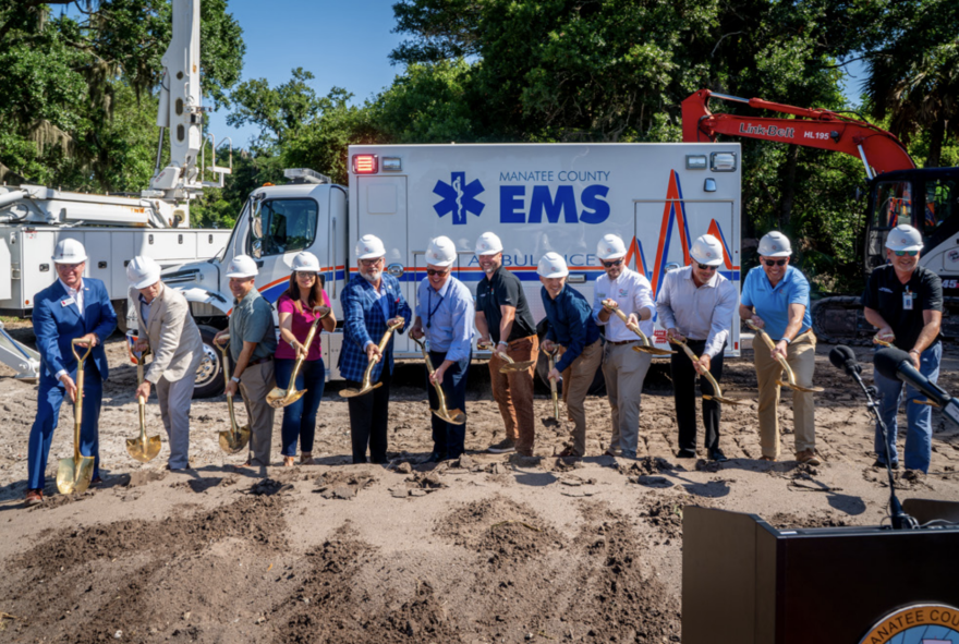 Men in dress shirts and hard hats digging dirt