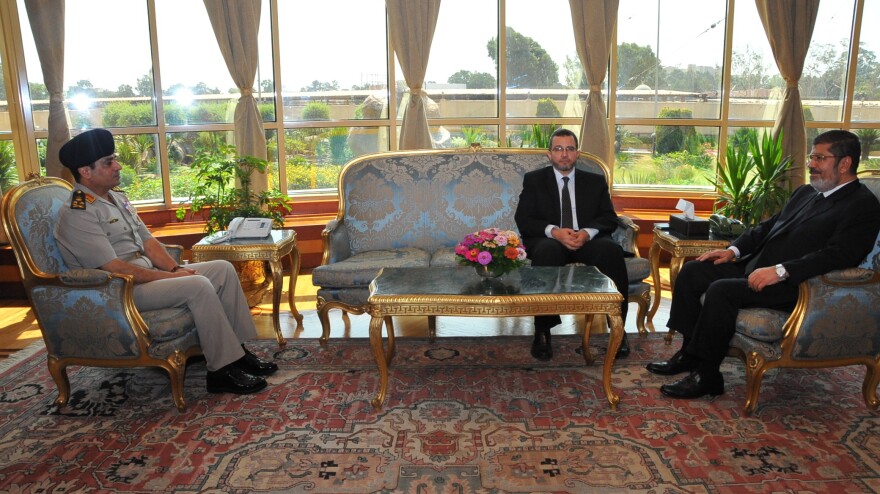 <strong>Before The Fall:</strong> Then-Egyptian President Mohammed Morsi (right) met Monday with Prime Minister Hesham Kandil (center) and Defense Minister Gen. Abdel-Fattah al-Sisi in Cairo. Since then, the military has ousted Morsi, suspended the constitution and imposed a "road map" for political transition in Egypt after the president refused calls to step down.