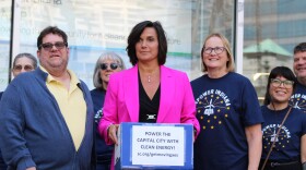 AES Director of Public Relations Kelly Young accepted petitions from activists calling the company to move to clean energy