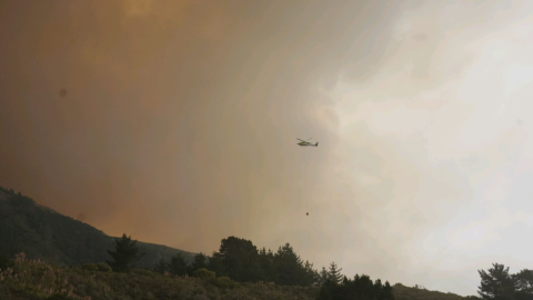 A helicopter carrying water to the Plaskett Fire.