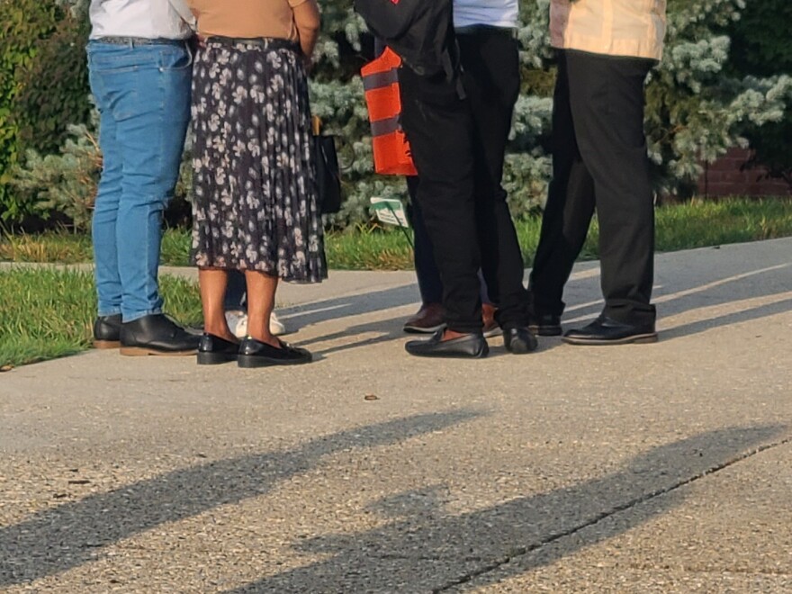legs of people standing on a driveway
