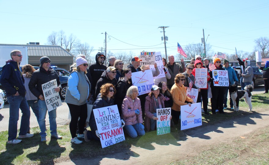 A group of protestors pose for a photo together with their signs.