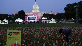 A demonstrator stands among battery powered candles in paper bags during a vigil in protest against potential cuts to Medicaid in Washington, D.C. on July 23, 2025.