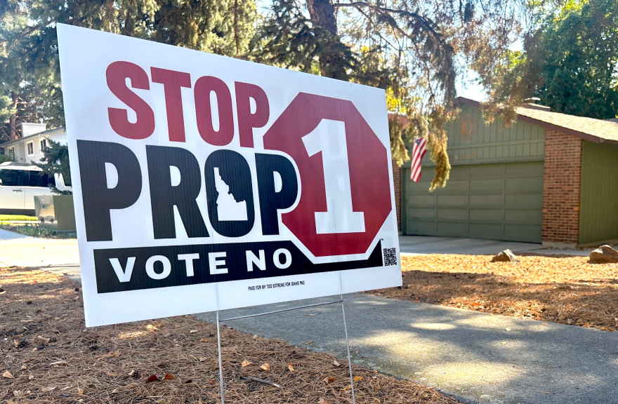 A yard sign in front of a home that says "Stop Prop 1, vote no" with an outline of Idaho inside the O in Prop. The sign also notes in much smaller text that it was paid for by Too Extreme for Idaho PAC.