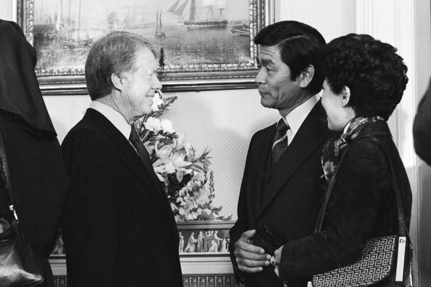 FILE - Hawaiʻi Gov. George Ariyoshi, center, and his wife Jean chat with President Jimmy Carter during a White House reception for governors in Washington, Jan. 21, 1977. (AP Photo, File)