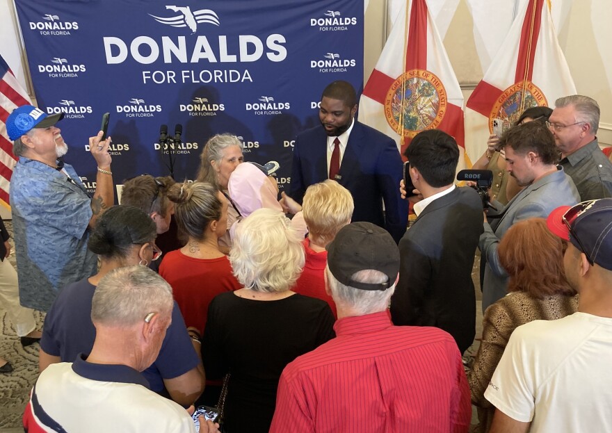 Man speaking before a crowd and shaking hands