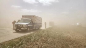 An ambulance on the side of the road during a dust storm