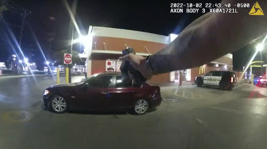 In this image taken from Oct. 2, 2022 police body camera video and released by San Antonio Police Department, Erik Cantu drives away as San Antonio Police officer James Brennand shoots his pistol at the car in a fast food restaurant parking lot in San Antonio, Texas. Brennand opened fire several times wounding the unarmed teenager as he drove away.