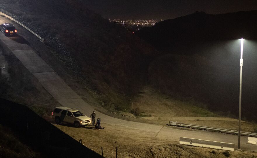 A Border Patrol agent arrests a group of Central American migrants after crossing the U.S.-Mexico border fence from Tijuana to San Diego County late last year.