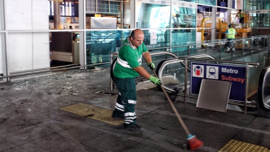 Workers clean the debris from yesterday's blasts at Ataturk Airport in Istanbul on Wednesday.