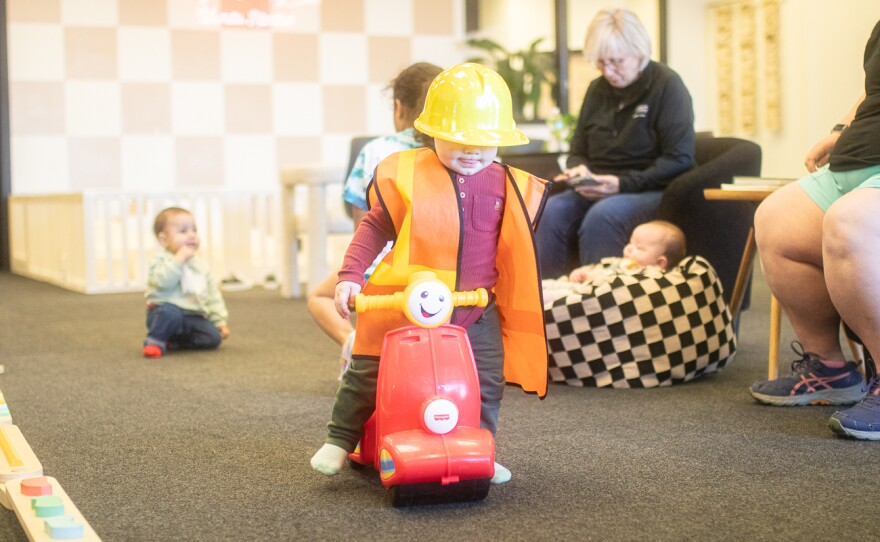 Kamari Adams walks with a fischer-price motorcycle toy. Individual monthly memberships cost $45 per month.