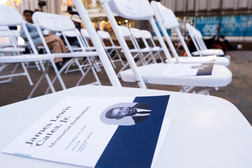 Programs for the memorial dedication of James Cates Jr. can be seen in the chairs of the ceremony near the pit area of UNC Chapel Hill on Nov. 21, 2022.