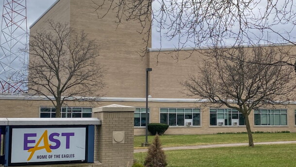 East High School is shown with the school name on a monument out front, and the building in the background.