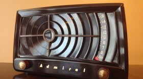 Photograph of a brown table top radio made by Admiral. The design of this vintage Bakelite tube radio is known as a bullseye, because the cabinet resembles a bullseye.  