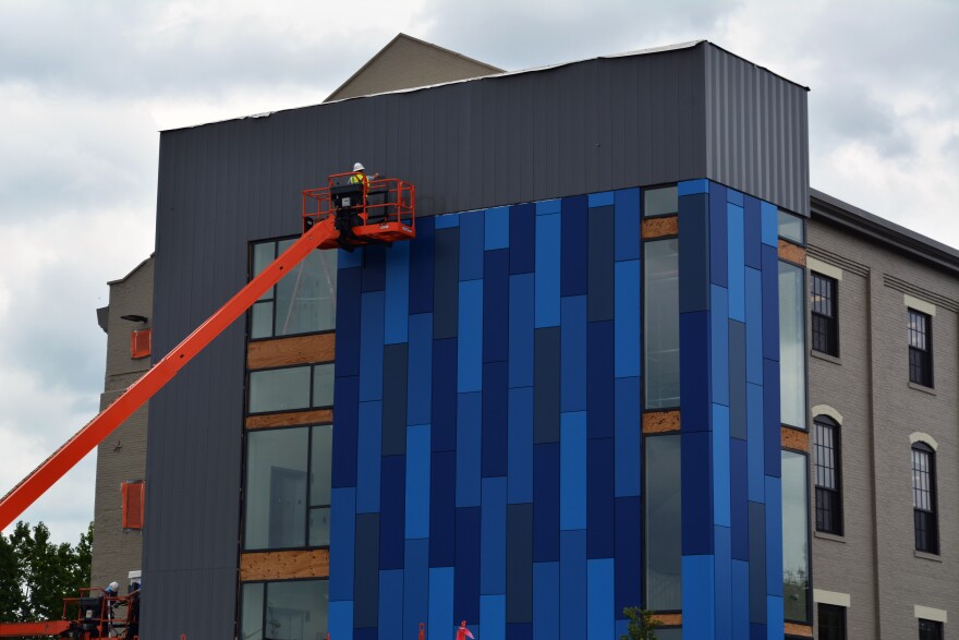 An employee installs cameras on exterior of new north stair tower at the Hauer Music Building 