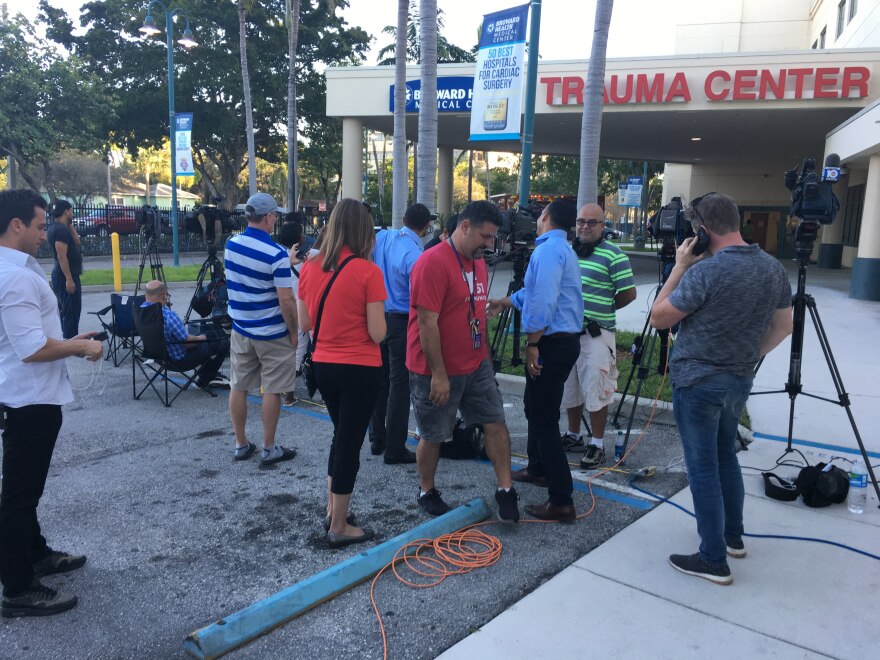 Reporters gather at a media staging area outside the hospital, waiting for updates about shooting victims.