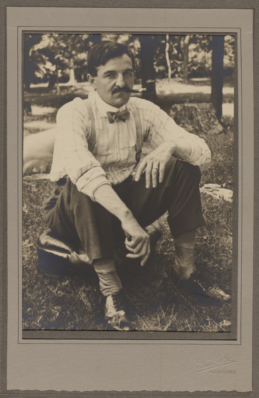 Mayor Daniel Hoan, smoking a pipe in a park.