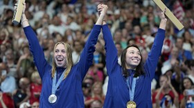 Gold medalist Torri Huske, of the United States, right, stands on the podium with teammate and silver medalist Gretchen Walsh following the women's 100-meter butterfly final at the 2024 Summer Olympics, Sunday, July 28, 2024, in Nanterre, France.