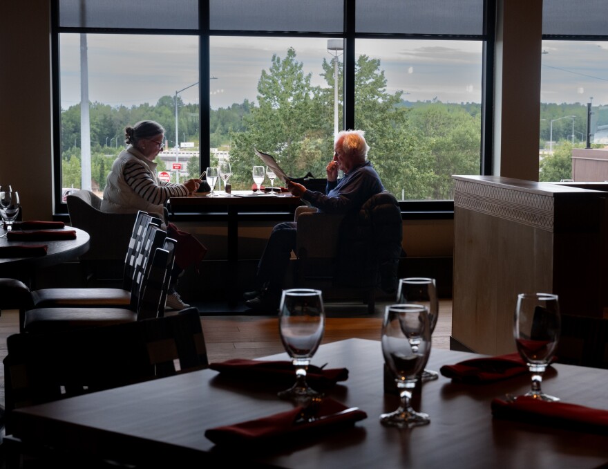 Two people sit at a table in a restaurant.