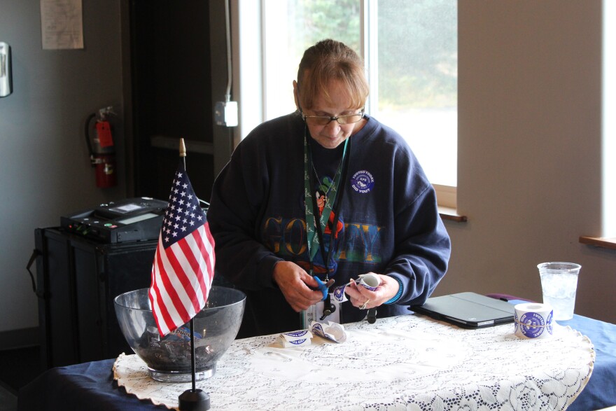 Patricia Wheeler separates "I Voted" stickers on Tuesday, Oct. 7, 2025 in Ninilchik, Alaska.