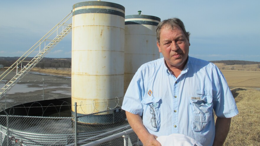 Jim Barrett stands next to a well pad on his farm in Bradford County, Pa. He accuses Chesapeake Energy of cheating him out of royalty money.