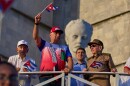 FILE - Cuba's President Miguel Diaz-Canel holds up a Cuban flag as he watches the May Day parade next to Raul Castro, second from right, and Raul Castro's grandson, Raul Guillermo Rodriguez Castro, at Revolution Square in Havana, May 1, 2025. (AP Photo/Ramon Espinosa, File)