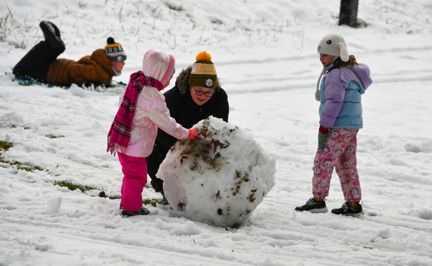 Heather Cook, Royce Hariston, 4, Sierra Scott, 7, and Beryx Hariston, 12, build a snowman in Kirby Park Sunday afternoon.